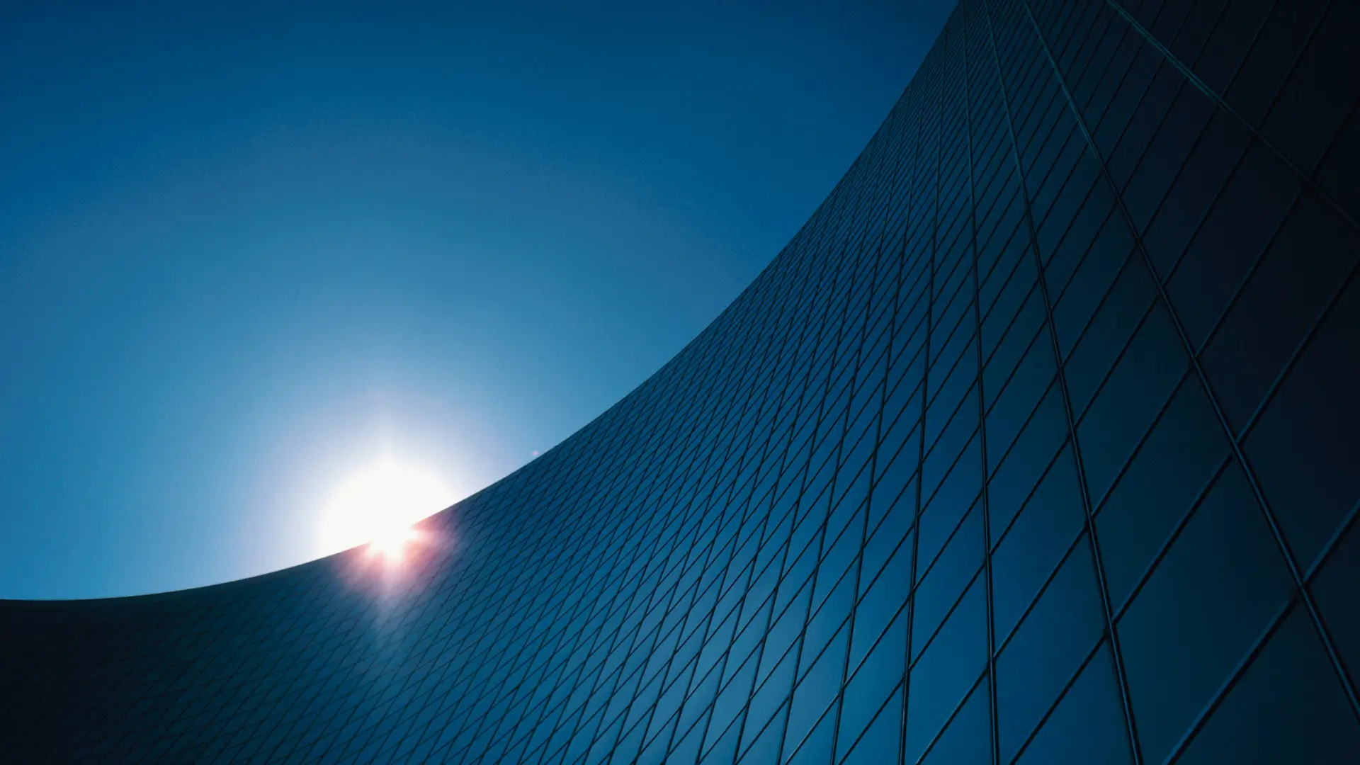 The curved glass face of an office tower
